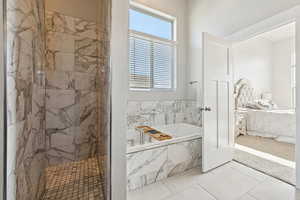 Primary ensuite bathroom featuring a bath, a marble finish shower, and tile patterned flooring