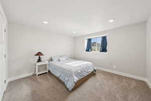 Bedroom with light colored carpet and recessed lighting