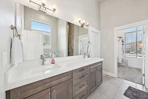 Full bathroom featuring double vanity and light tile patterned floors