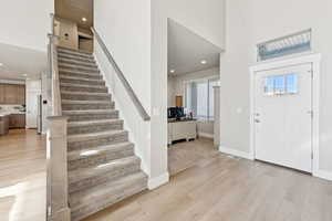 Foyer with LVP floors, recessed lighting, stairway, and a high ceiling