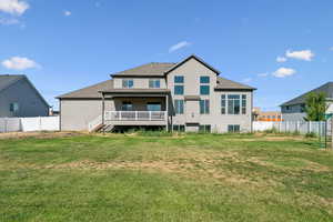 Back of property with a fenced backyard, stucco siding, large covered deck, and a shingled roof
