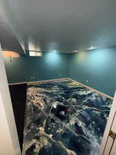 Below grade area featuring a textured ceiling and baseboards