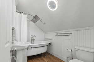ADU above the garage - bathroom featuring lofted ceiling, dark wood-style flooring, and a textured ceiling