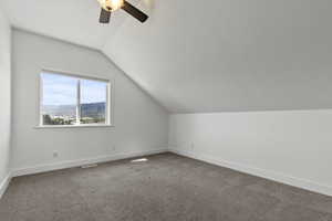 Bonus room featuring vaulted ceiling, carpet flooring, and ceiling fan