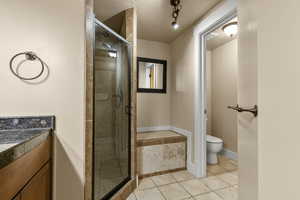 Full bath featuring a stall shower, light tile patterned floors, and vanity