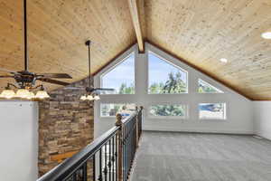 Additional living space featuring a wooden ceiling with exposed beams, high vaulted ceiling, carpet floors, and a ceiling fan