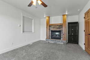 Primay bedroom with carpet flooring, a fireplace, and a ceiling fan