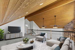 Living area with carpet flooring, vaulted ceiling, wooden ceiling, and ceiling fan