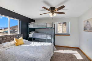 Carpeted bedroom with a ceiling fan and a mountain view