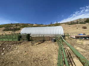 View of yard featuring an outdoor structure, a rural view, and an exterior structure