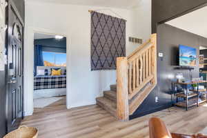 Staircase with wood finished floors and baseboards