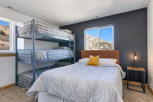 Carpeted bedroom with baseboards and a mountain view