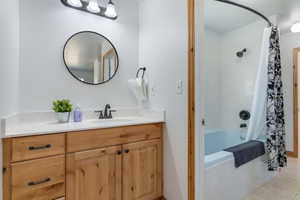 Full bath featuring shower / tub combo, vanity, and light tile patterned floors