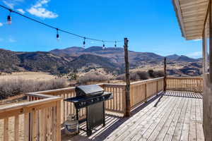 Wooden deck featuring a grill and a mountain view