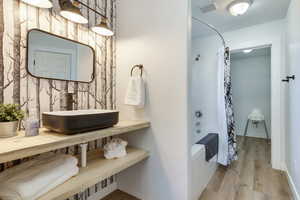 Full bathroom with shower / bath combo with shower curtain and wood finished floors