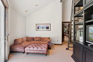 Living room with plenty of natural light, light carpet, recessed lighting, and high vaulted ceiling