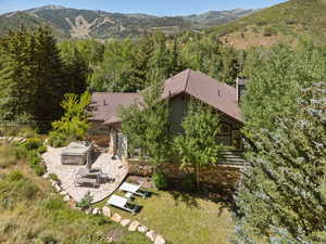 View from above of property featuring a mountainous background and a heavily wooded area