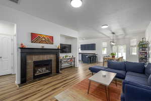 Living area with a tile fireplace and light wood-type flooring