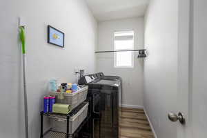 Washroom featuring wood finished floors and separate washer and dryer
