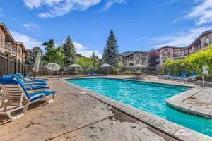 Community pool with a patio area and a residential view
