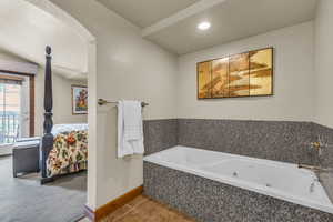 Bathroom with a tub with jets, tile patterned flooring, and recessed lighting