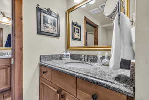Bathroom featuring vanity, a textured wall, and tile patterned floors