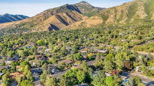 Aerial view of property and surrounding area featuring a mountain backdrop and nearby suburban area