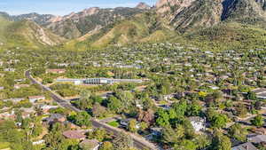 Aerial view of property and surrounding area featuring nearby suburban area and mountains