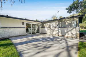 Rear view of property with brick siding