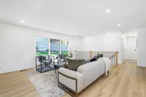 Living area with recessed lighting and light wood-type flooring