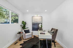 Home office featuring light wood-type flooring and recessed lighting
