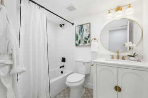 Bathroom with shower / bathtub combination with curtain, vanity, and light tile patterned flooring