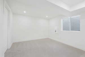 Carpeted empty room featuring recessed lighting