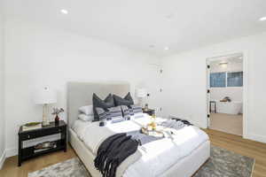 Bedroom featuring light wood-style flooring, recessed lighting, and ensuite bathroom