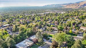 Aerial perspective of suburban area with mountains and a tree filled landscape