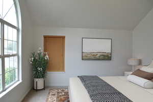 Carpeted bedroom featuring baseboards and vaulted ceiling