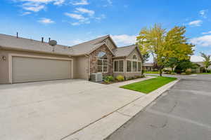 Single story home featuring stone siding, stucco siding, and a shingled roof