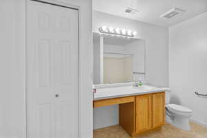 Bathroom featuring a closet, vanity, a shower, and light tile patterned floors