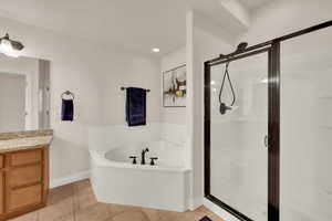 Bathroom featuring a garden tub, vanity, light tile patterned floors, a shower stall, and recessed lighting