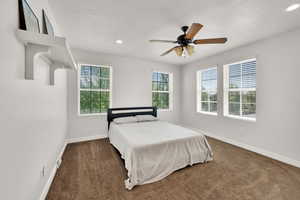 Bedroom with dark colored carpet, recessed lighting, and ceiling fan