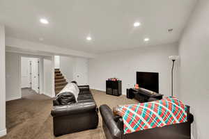 Carpeted living room featuring recessed lighting and stairway