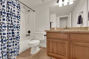 Bathroom featuring light tile patterned flooring, shower / bath combo, and vanity