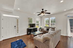 Living area with dark wood-style flooring, ceiling fan, recessed lighting, and a textured ceiling
