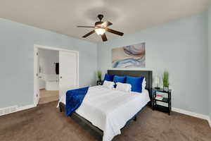 Carpeted bedroom featuring a ceiling fan and connected bathroom