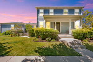 View of front facade with covered porch and a front lawn