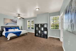 Bedroom with multiple windows, carpet floors, and ceiling fan