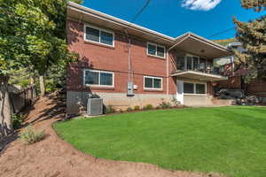 Rear view of property featuring a balcony and brick siding