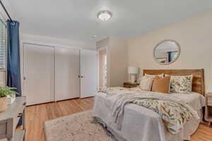 Bedroom with light wood-style floors and a closet