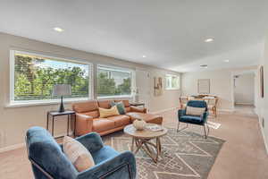 Carpeted living area featuring recessed lighting and baseboards