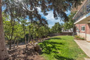 Fenced backyard with a balcony